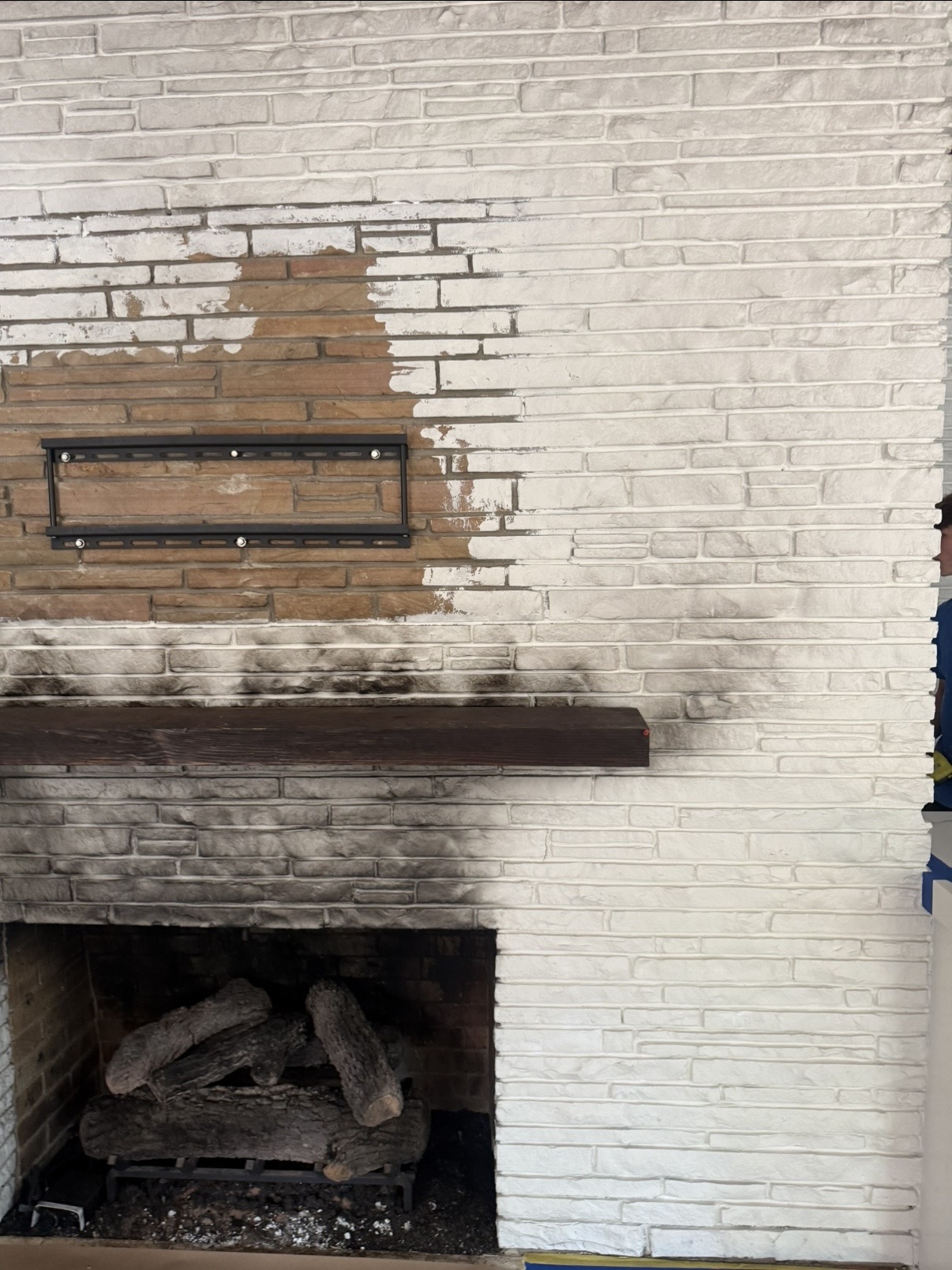 Brick fireplace halfway transformed from brown to bright white