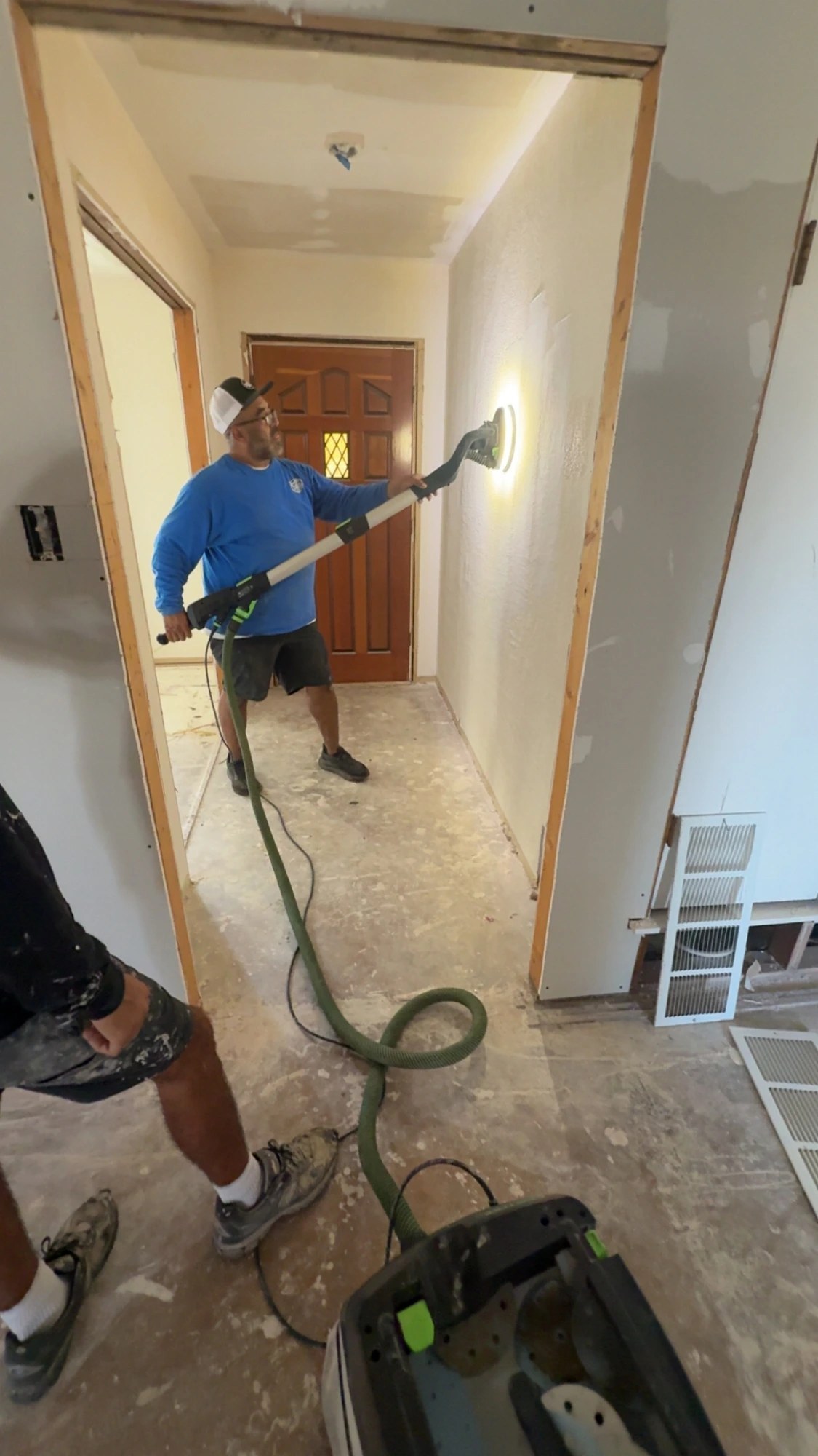 Xtra Clean crew member dust-free sanding walls before painting