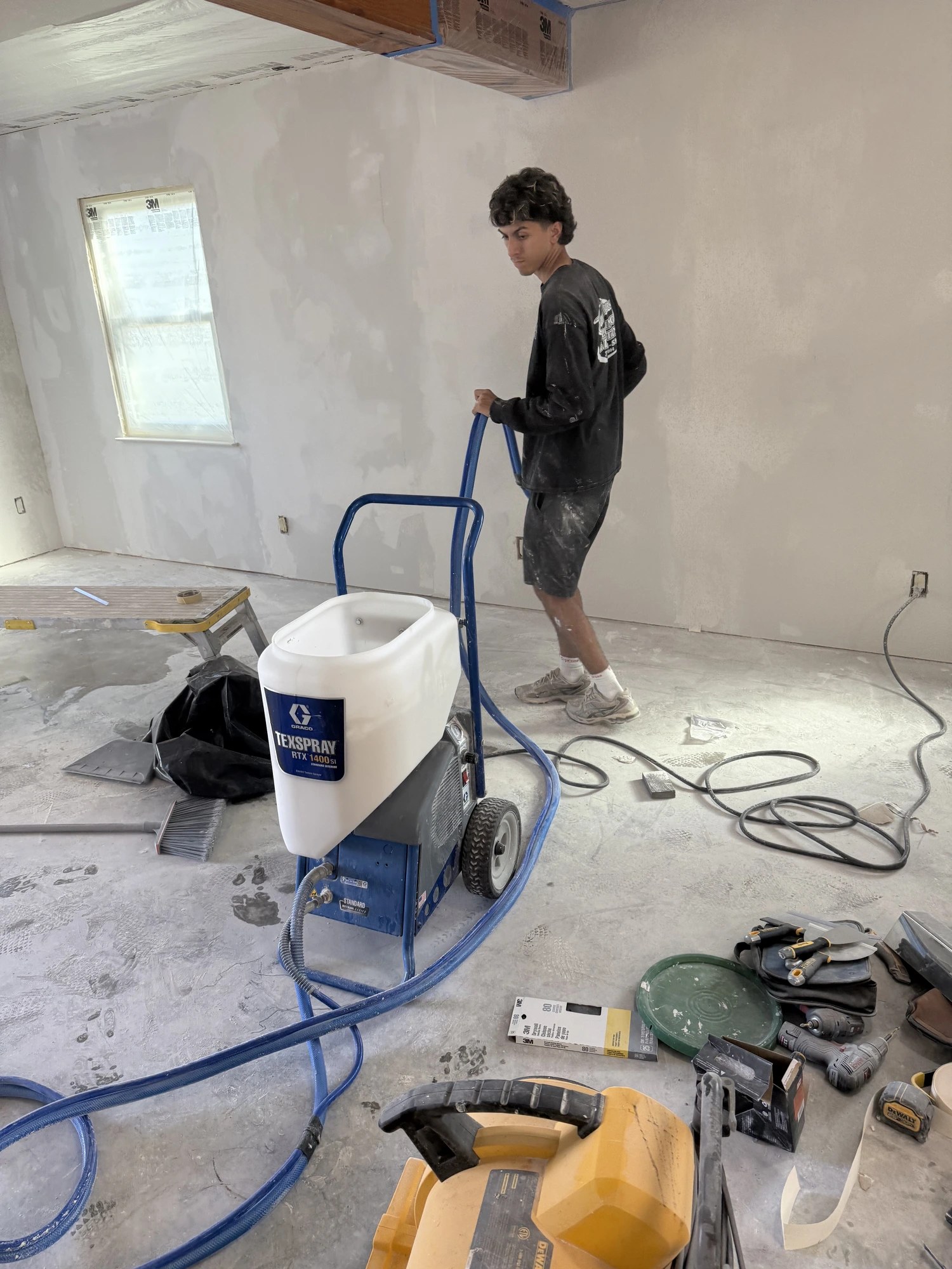 Professional texture spray rig in a room being resurfaced